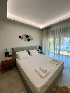 a bedroom with a large white bed with towels on it at ONDE BLU in Khránoi