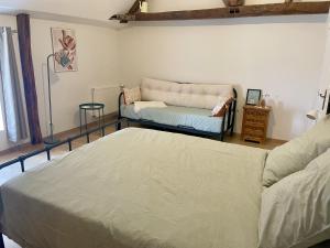 a living room with a bed and a couch at Le Logis du pic vert in Saint-Mathurin