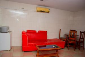 a living room with a red couch and a table at studio CHEZ VOUS in Lomé