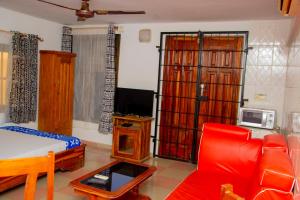 a living room with a red couch and a tv at studio CHEZ VOUS in Lomé