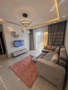a living room with a couch and a tv at Avenuo apartment in Hurghada