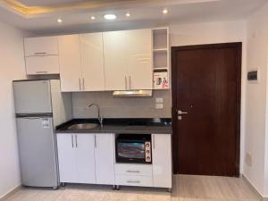 a kitchen with white cabinets and a refrigerator at Avenuo apartment in Hurghada