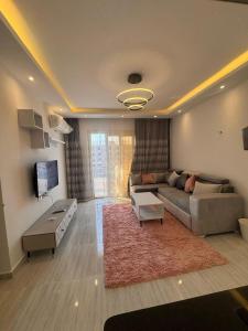 a living room with a couch and a tv at Avenuo apartment in Hurghada +5 photos
