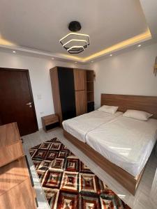 a bedroom with a large bed and a rug at Avenuo apartment in Hurghada