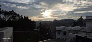 a view of the sunset from the roof of a building at Clouds Inn Holidays Homes Stay in Ooty