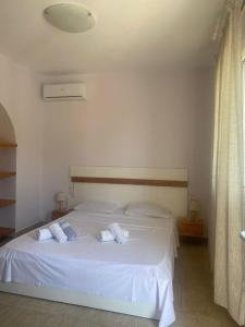 Un dormitorio con una cama blanca con toallas. en Castel Room, en Himare