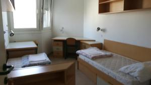 a small room with two beds and a desk at Hostel Rožna dolina, Dom XIV in Ljubljana