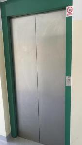 a metal garage door in a building with a sign at Hostel Rožna dolina, Dom XIV in Ljubljana
