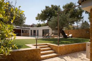 a view of a house with a garden and stairs at Aeolia Villa Athenian Riviera in Anavissos