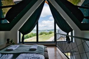 a bedroom with a bed and a large window at Panorama Hills by Housine in Jaszczurowa