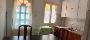 una cucina con tavolo, sedie e finestra di Chris's house in Spetses a Spetses Altre 19 foto