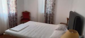 una camera da letto con un letto bianco e una sedia rossa di Chris's house in Spetses a Spetses