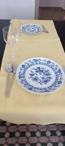 un tavolo con due piatti blu e bianchi e un bicchiere di Chris's house in Spetses a Spetses