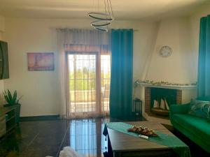 a living room with a green couch and a window at Natalie’s House in Alexandroupoli