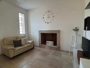 a living room with a couch and a clock on the wall at Villetta Aleanna in Serranova