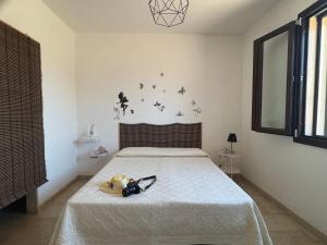 a bedroom with a bed with a white bedspread at Villetta Aleanna in Serranova