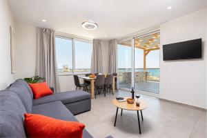 a living room with a blue couch and a table at Meli apartments Paleochora in Palaiochora