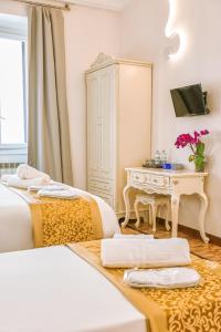 a bedroom with two beds and a desk and a mirror at Casa Pan in Rome
