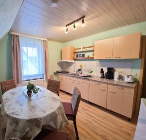 eine Küche mit einem Tisch und Stühlen sowie einem Tisch und einem Tisch und einer Küche in der Unterkunft Ferienwohnung Seestern Ückeritz in Ückeritz