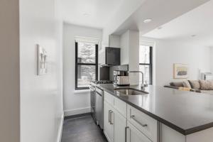 cocina blanca con fregadero y encimera en Blueground Lincoln Sq gym wd nr park NYC-1849, en Nueva York 15 fotos más