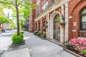 Un edificio de ladrillo con flores al lado de una calle en Blueground Lincoln Sq gym wd nr park NYC-1849, en Nueva York