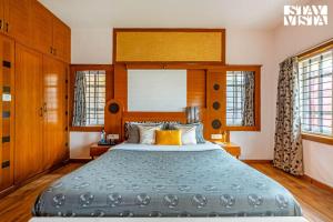 Un dormitorio con una cama grande con cabecero de madera. en The Secret Glen by VEO - Part of StayVista with BBQ & Bonfire, en Ooty