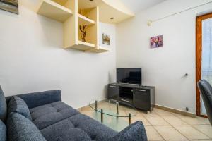 a living room with a blue couch and a tv at Ferienwohnung 5235-1 in Drenje in Drenje