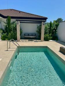 a swimming pool in front of a house with a patio at Courtyard Villa, Aleksandrovo in Aleksandrovo +12 photos