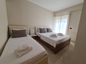 都拉斯Hana's Apartment的有两张床和一扇窗户的卧室