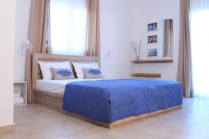 a bedroom with a bed with a blue blanket on it at Krinis Apartments in Rhodes Town