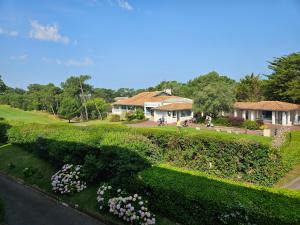 a house with a hedge and flowers in a park at Résidence Chiberta Anglet océan golf surf in Anglet