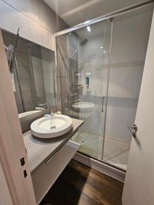 a bathroom with a sink and a glass shower at Résidence Chiberta Anglet océan golf surf in Anglet +22 photos