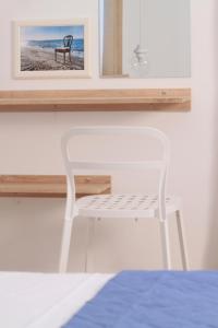 a white chair sitting in a room with a mirror at Krinis Apartments in Rhodes Town