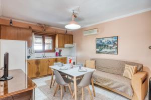 a kitchen and a living room with a table and a couch at Antonela's Holiday Cottage in the countryside - Ground Floor in Kómi