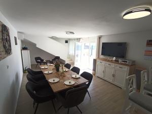 Un comedor con mesa y sillas y un televisor. en Vila Ema Dramalj, en Dramalj