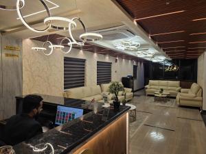 a man sitting at a bar in an office lobby at Hotel Deccan Park in Haidar Sāhibgūda
