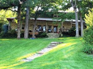 ein Haus mit einem Steinweg vor einem Hof in der Unterkunft Waterfront Cabin Rental for Groups of 16 with Jacuzzi Bathtub in Texas Hill Country in Marble Falls