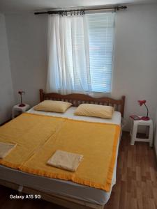 a bedroom with a large bed with a window at Radovici Family House in Tivat