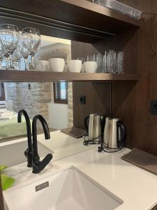 a kitchen counter with a sink and glasses on a shelf at Casa Del Sol Pietra Kotor in Kotor +44 photos