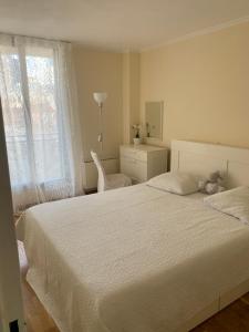 a bedroom with a white bed with a teddy bear on it at DEUX-PIECES PUTEAUX, Front de Seine in Puteaux