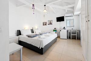 a bedroom with a large bed in a white room at Hotel Selini in Agios Nikitas