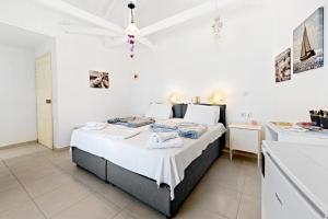 a bedroom with a bed with white walls and a ceiling at Hotel Selini in Agios Nikitas