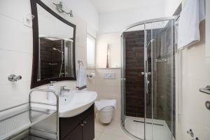 a bathroom with a sink and a glass shower at The Tribunj Suites in Tribunj +34 photos