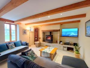 a living room with a couch and a tv at Maison Indépendante Sur Jardin in Mahalon
