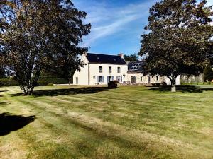a large white house with trees in the yard at Maison Indépendante Sur Jardin in Mahalon
