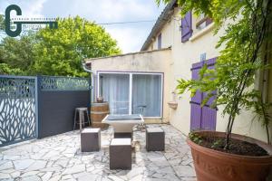 a patio with a fence and a sink in a yard at Séjour détente avec spa, piscine et sauna in Mas-Saintes-Puelles