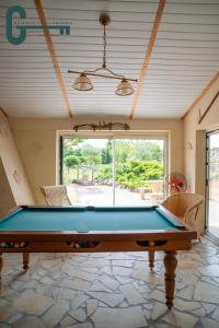 a pool table in the middle of a room at Séjour détente avec spa, piscine et sauna in Mas-Saintes-Puelles