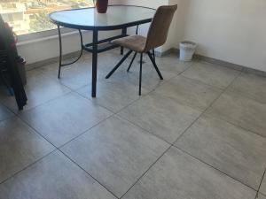a table and chair sitting on a tiled floor at Fantastic sea views in Larnaka