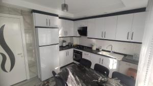 a kitchen with white cabinets and a white refrigerator at Engin HOME in Pamukkale