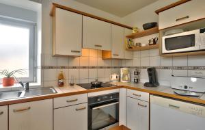 a kitchen with white cabinets and a sink and a microwave at Maison Indépendante Au Calme in Mahalon +10 photos